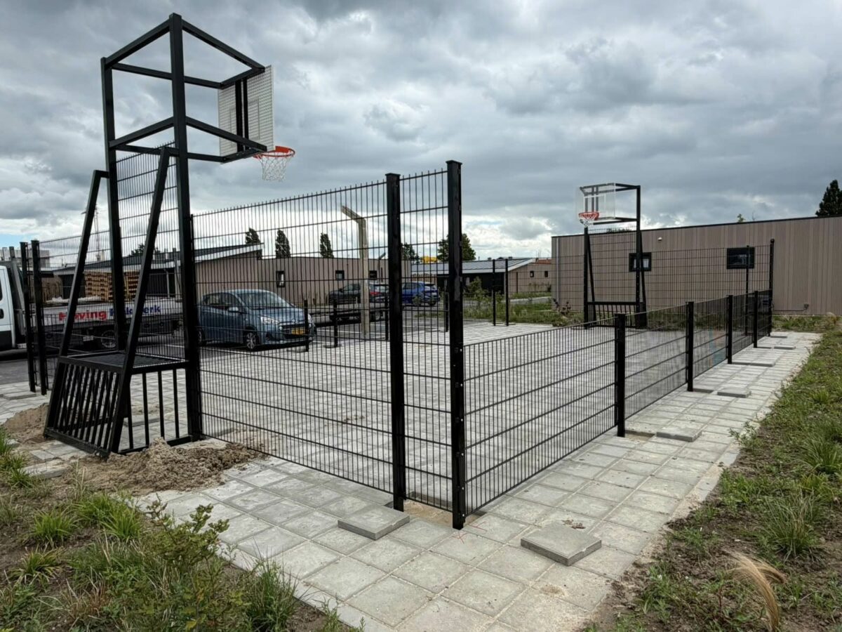 Maatwerk pannakooi met basketbal geplaatst in Yerseke 4 Basketbalvoorziening met geluidsarm roosterbord en rode basketbalring gemonteerd boven voetbaldoel